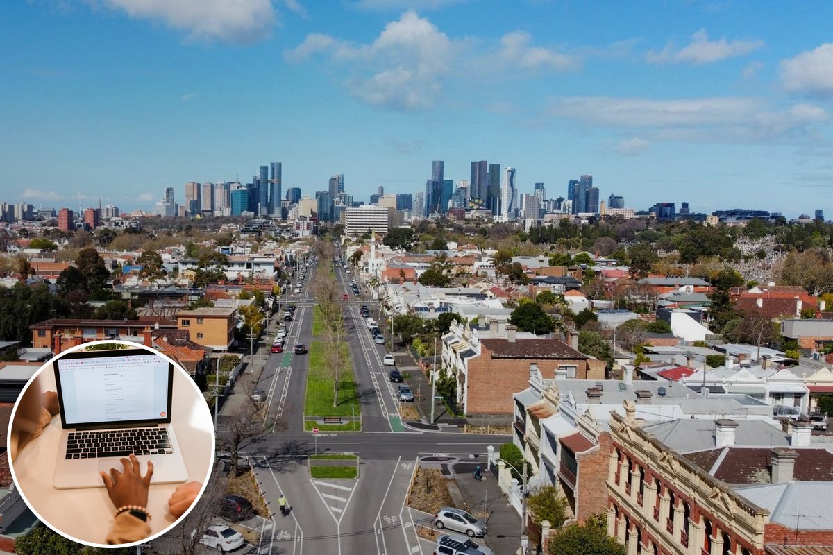 Aerial view over inner-northern Melbourne rooftops with the city skyline on the horizon.
