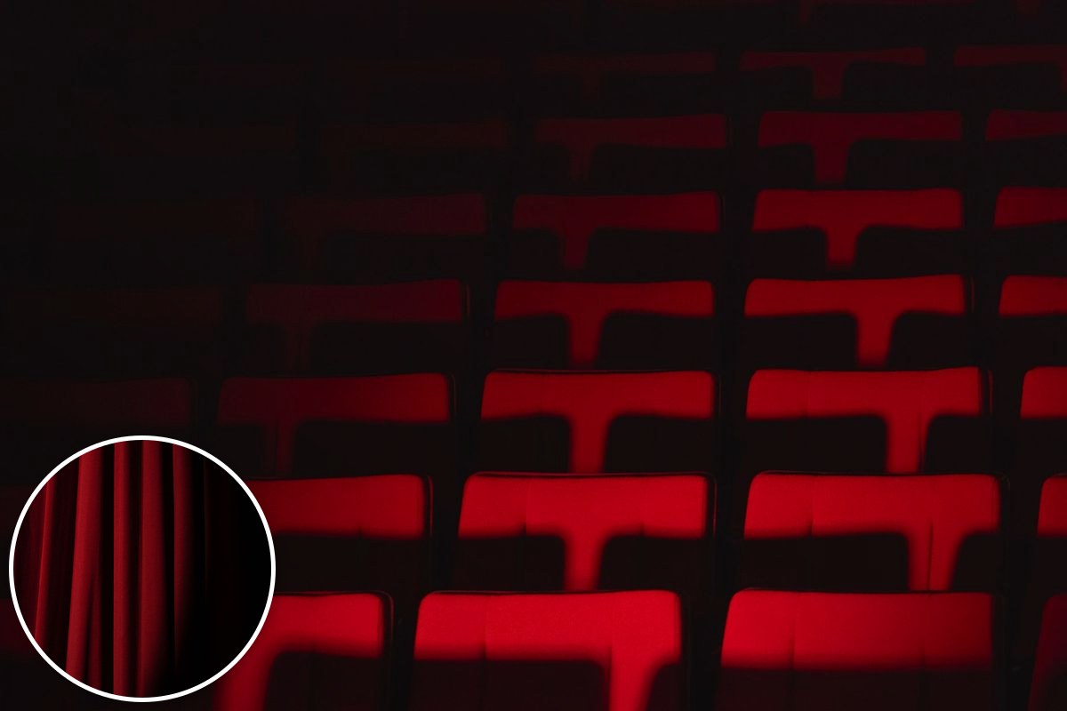 Rows of empty red theatre seats lit by dramatic side lighting.