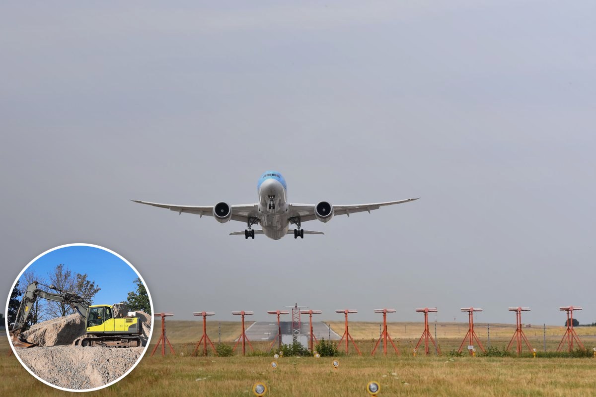 A wide-body passenger jet taking off over runway approach lights.