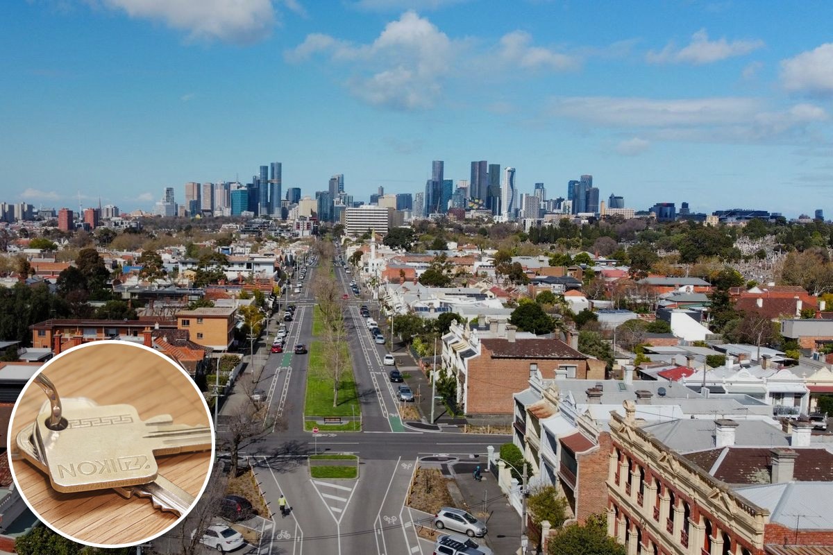 Aerial view of inner-Melbourne terrace-house rooftops with the CBD skyline behind.