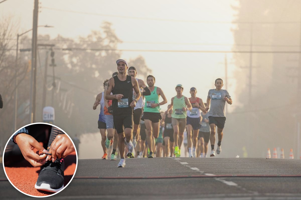 A pack of runners strides down an open road through morning mist during a mass-participation road race.