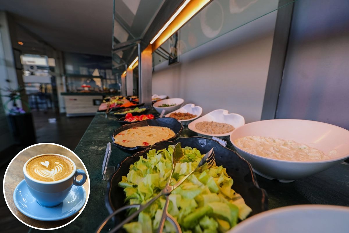 A cafeteria-style counter lined with bowls of fresh salads and market-plate dishes.
