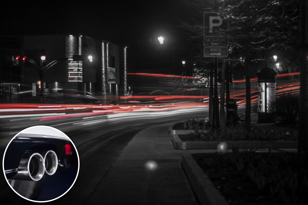 Long-exposure red and white light trails from traffic along a city street at night.