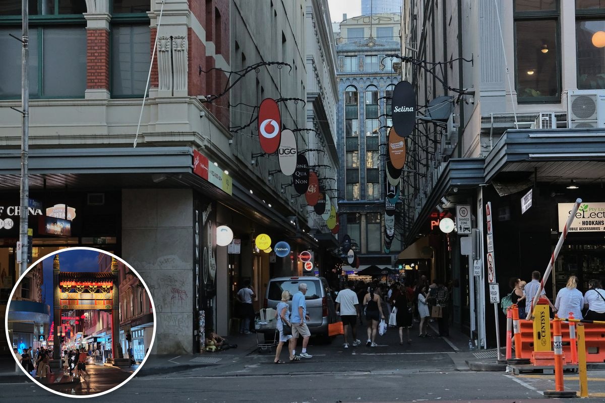 Shoppers walking through a busy Melbourne laneway lined with shopfronts and hanging signage.