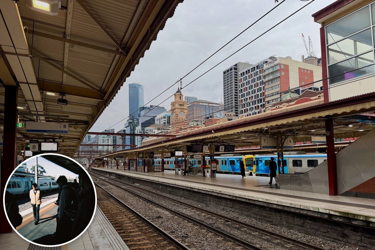 Flinders Street Station platforms with Metro trains waiting and the station clock tower behind.