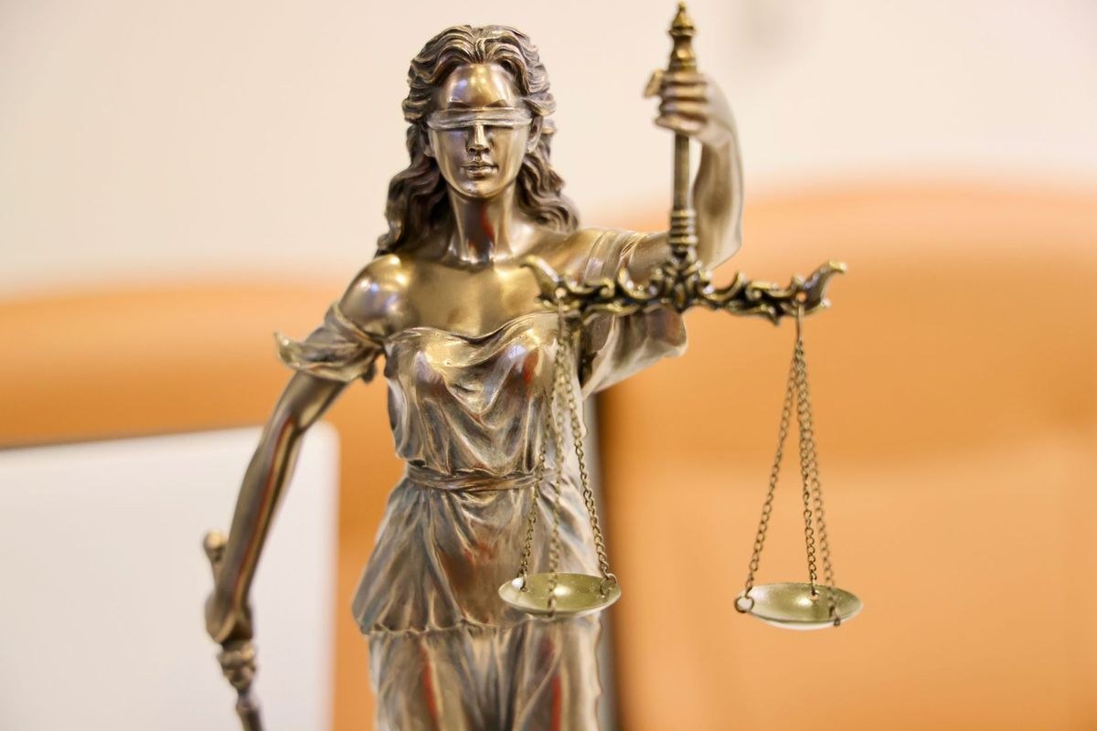 A brass statue of Lady Justice, blindfolded and holding scales, symbolising the courts.